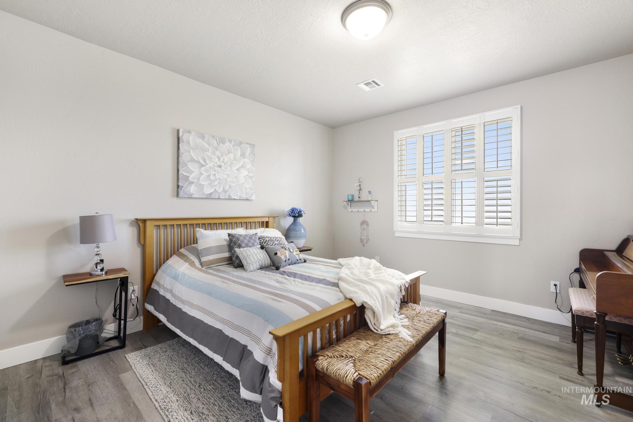 758 Cedar Crk Road Rogerson, ID 83302 - Photo 15 of 50 Room featuring wood-finish flooring, a ceiling-mounted light fixture, and a window with plantation shutters