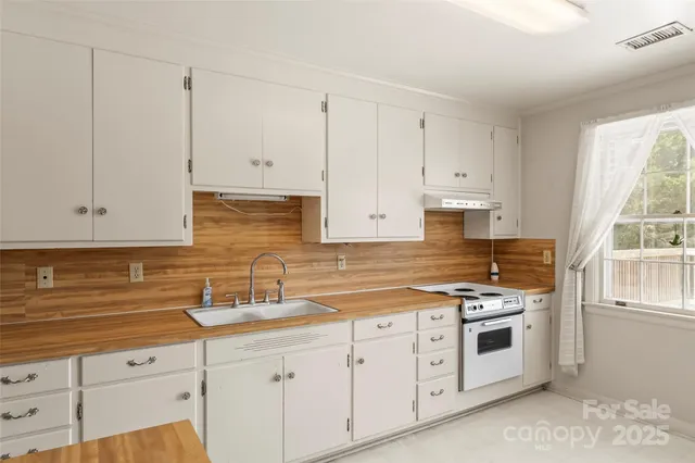 a kitchen with granite countertop white cabinets and white appliances