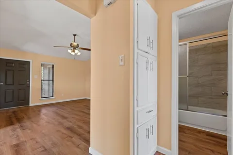 a view of a big room with wooden floor and windows