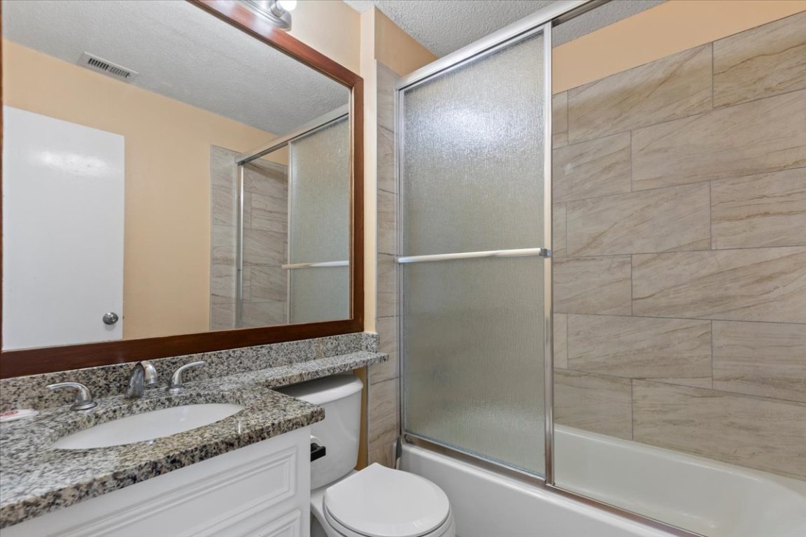 10616 Mellow Meadow Drive, Unit 21C Austin, TX 78750 - Photo 22 of 39 a bathroom with a granite countertop sink toilet and shower