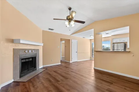 a view of empty room with wooden floor and fireplace