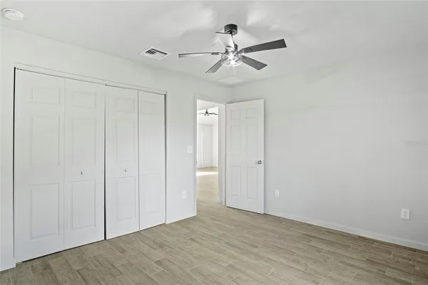 a view of a livingroom with a ceiling fan & hardwood floor