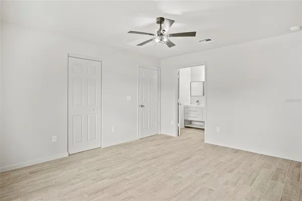 an empty room with window and ceiling fan