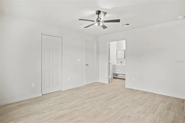 an empty room with window and ceiling fan