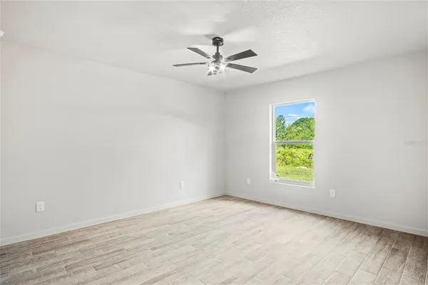 an empty room with a window and a fan