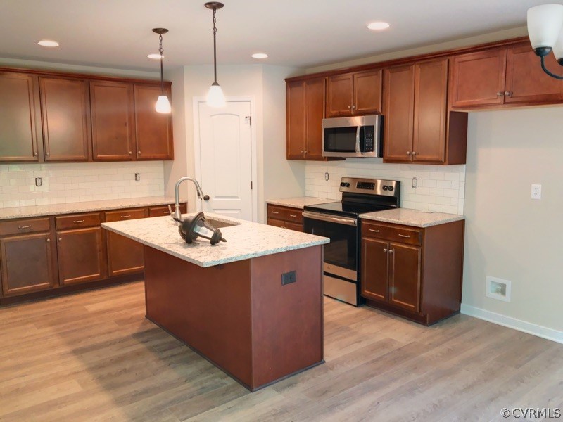 4919 Appelman Ridge Chesterfield, VA 23832 - Photo 3 of 6 a kitchen with stainless steel appliances granite countertop wooden cabinets a sink a stove a refrigerator and a microwave