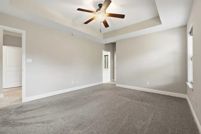 an empty room with closet and a chandelier fan