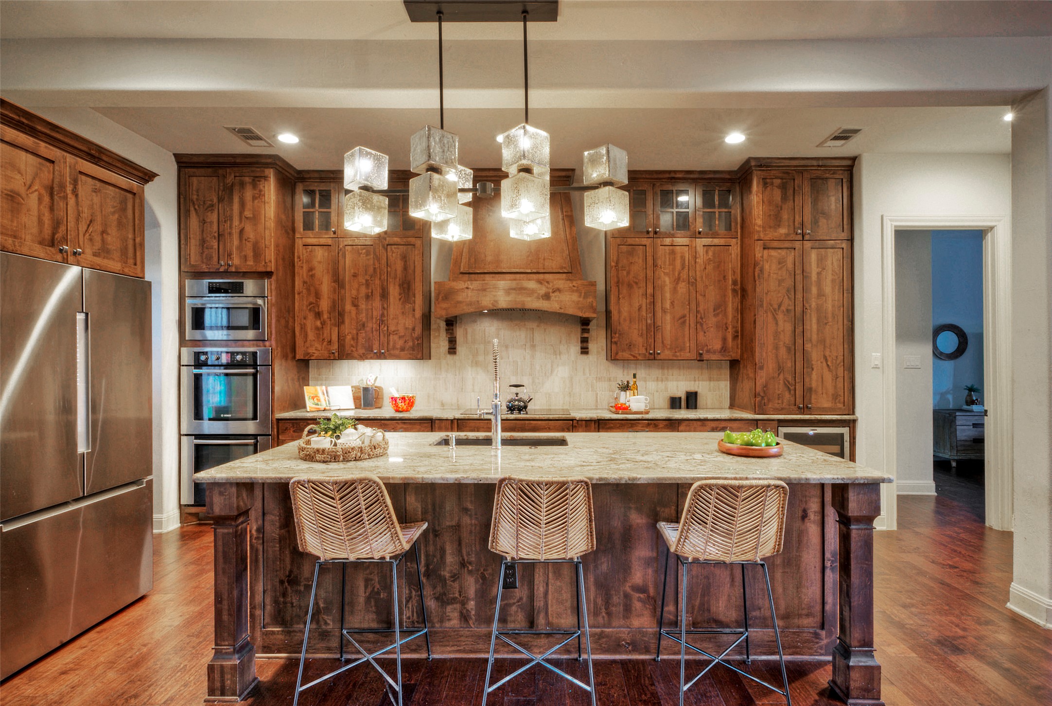 7 Parkside Road The Hills, TX 78738 - Photo 11 of 36 Kitchen featuring stainless steel appliances, wood finish cabinetry, light stone countertops, and a breakfast bar