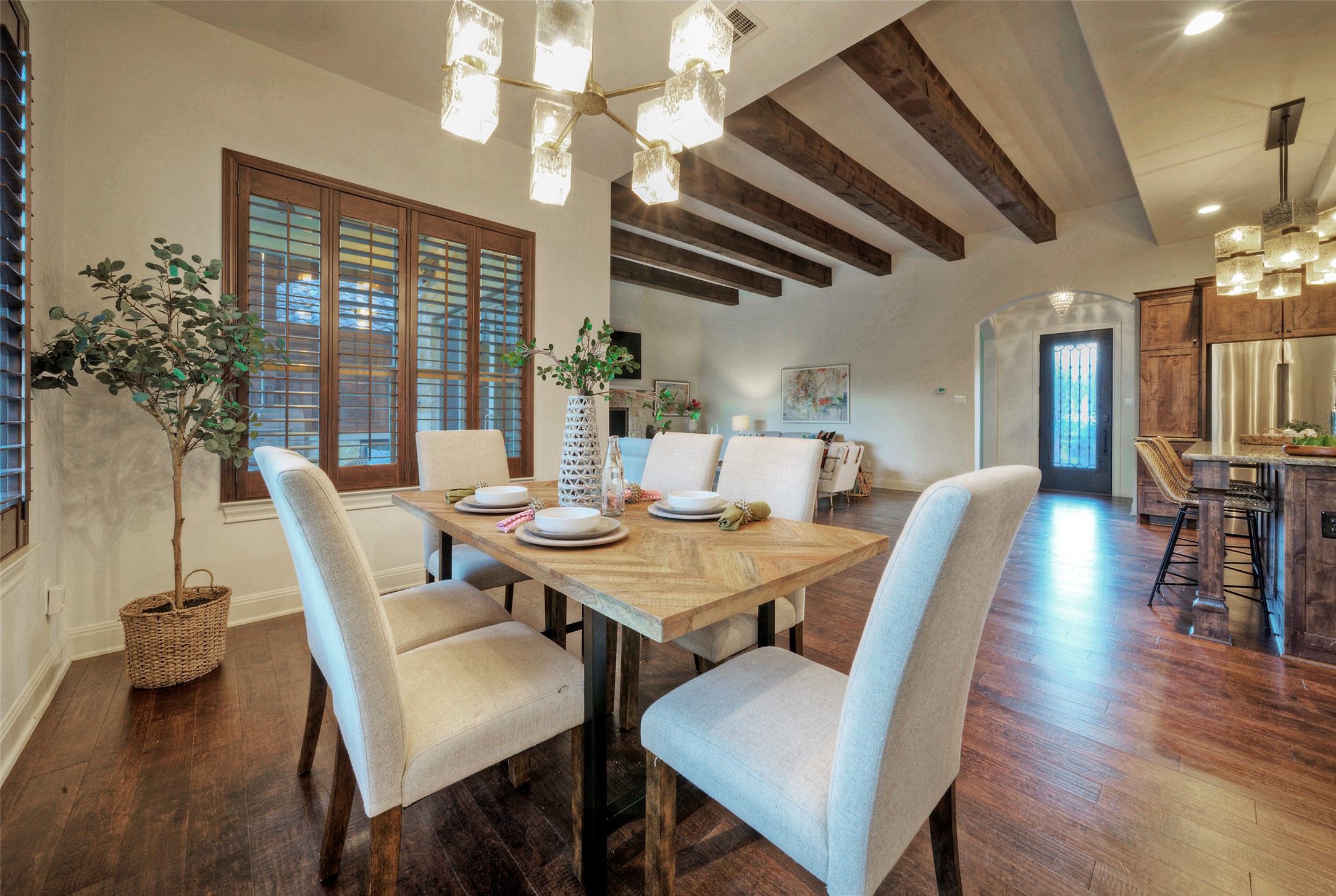7 Parkside Road The Hills, TX 78738 - Photo 12 of 36 Dining room featuring arched walkways, hanging lights, beamed ceiling, and dark wood-type flooring
