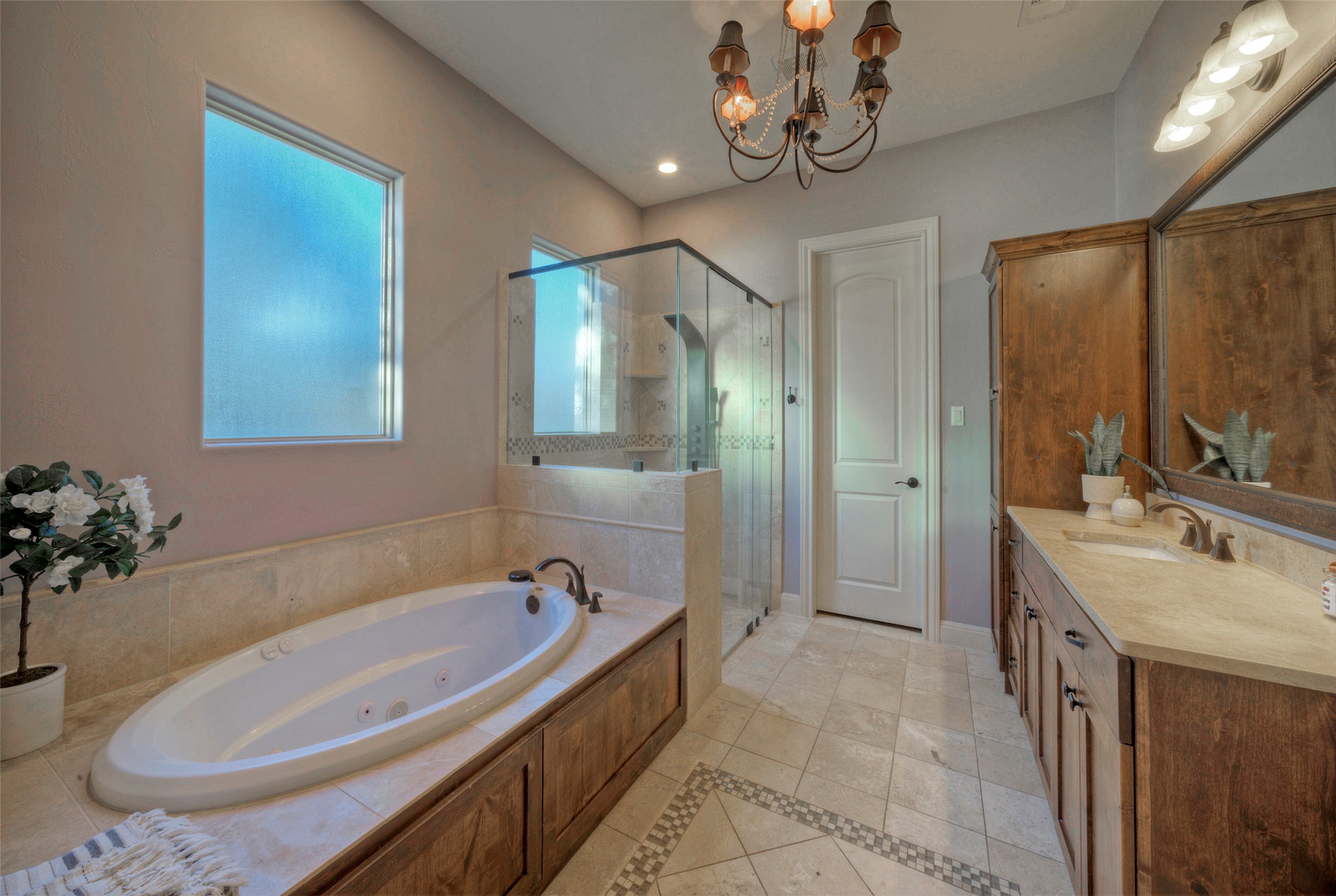 7 Parkside Road The Hills, TX 78738 - Photo 18 of 36 Bathroom featuring vanity, a chandelier, a stall shower, and a tub with jets