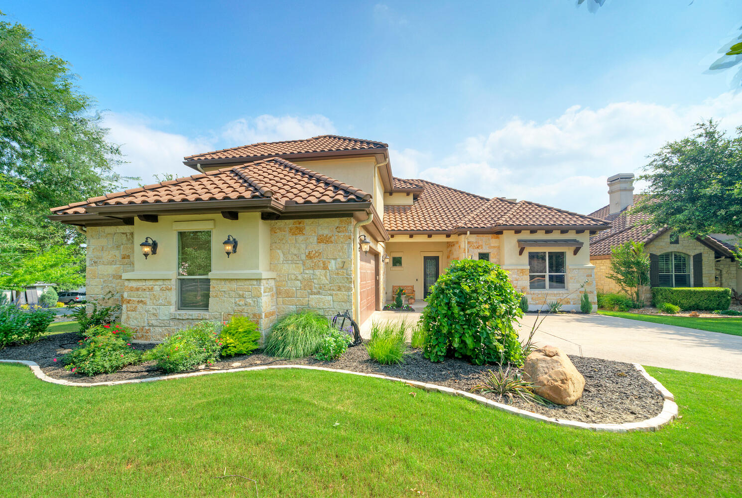7 Parkside Road The Hills, TX 78738 - Photo 2 of 36 Mediterranean / spanish house with stone siding, a front yard, driveway, and an attached garage