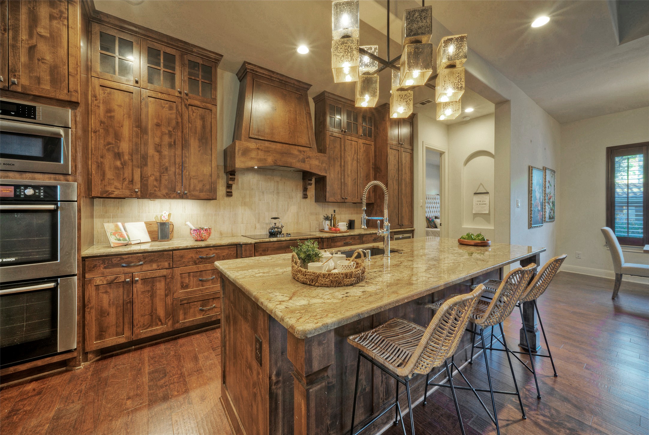 7 Parkside Road The Hills, TX 78738 - Photo 8 of 36 Kitchen with stainless steel double oven, dark wood-style flooring, glass insert cabinets, and a kitchen breakfast bar