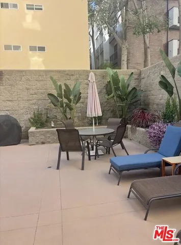 a building outdoor space with patio furniture and potted plants