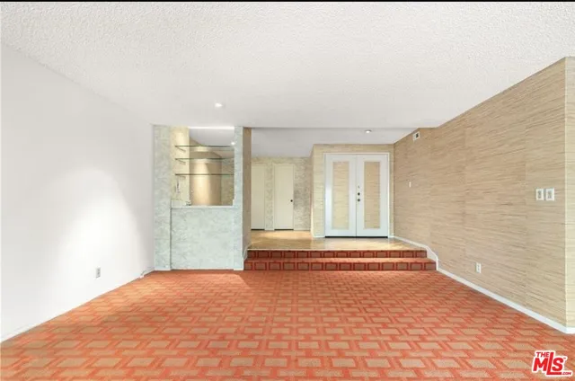 a view of an empty room with a fireplace and a window