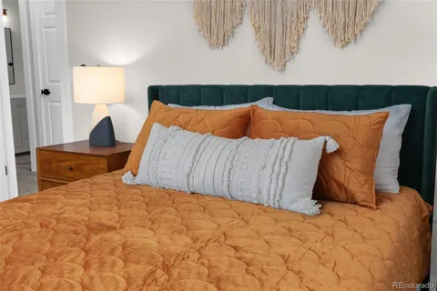 a bedroom with a bed and painting on the wall
