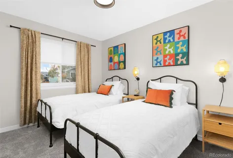 a bedroom with a bed and a table with painting on the wall
