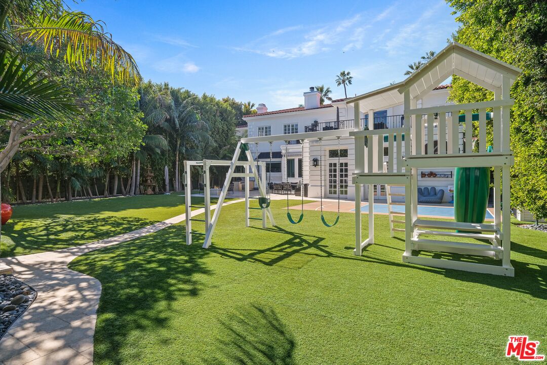 708 North Hillcrest Road Beverly Hills, CA 90210 - Photo 9 of 11 a view of a house with swimming pool and a yard