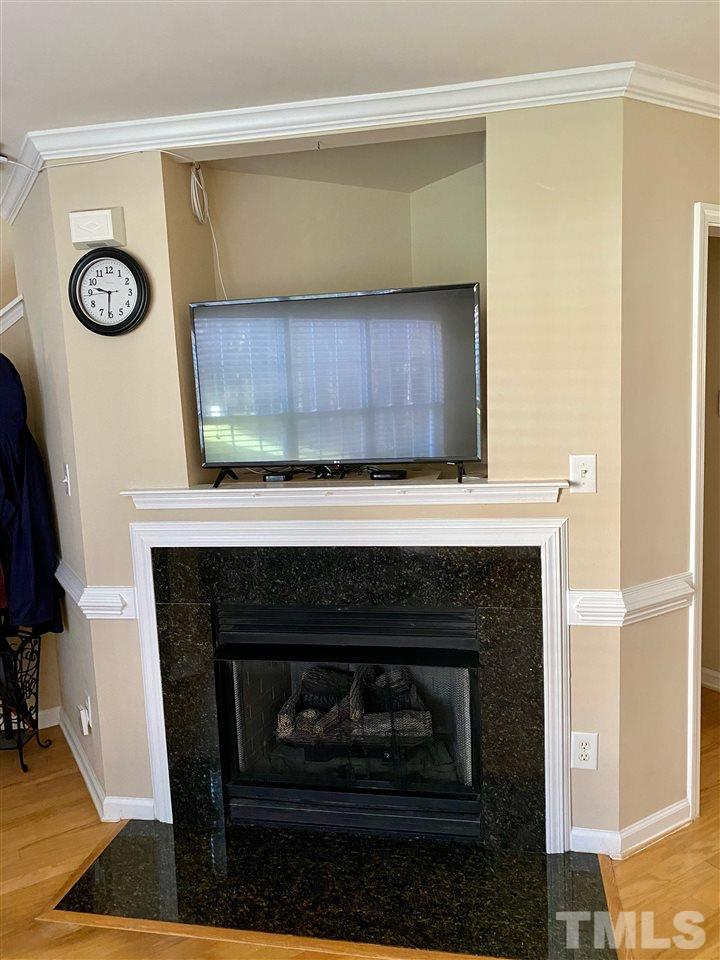 9910 Layla Avenue Raleigh, NC 27617 - Photo 5 of 13 a living room with a fireplace and a table
