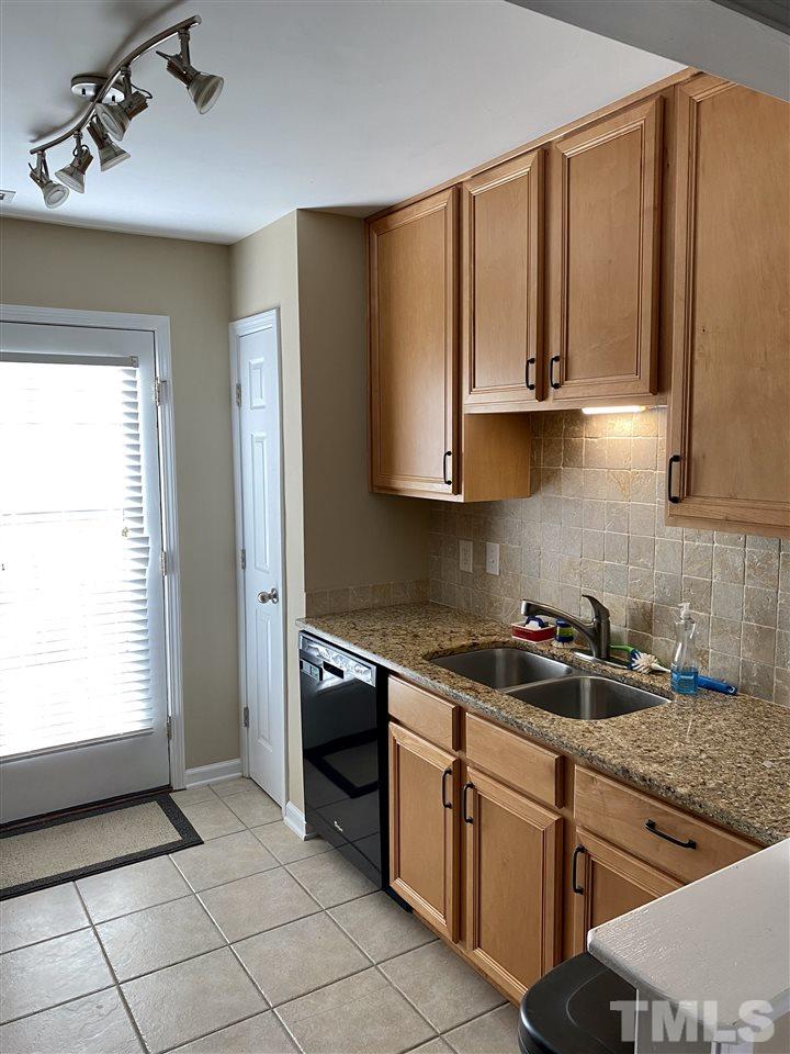 9910 Layla Avenue Raleigh, NC 27617 - Photo 6 of 13 a kitchen with stainless steel appliances granite countertop a sink stove and cabinets