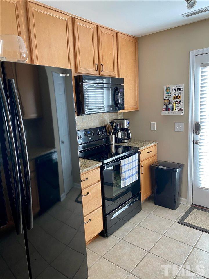 9910 Layla Avenue Raleigh, NC 27617 - Photo 7 of 13 a kitchen with stainless steel appliances a refrigerator sink and stove