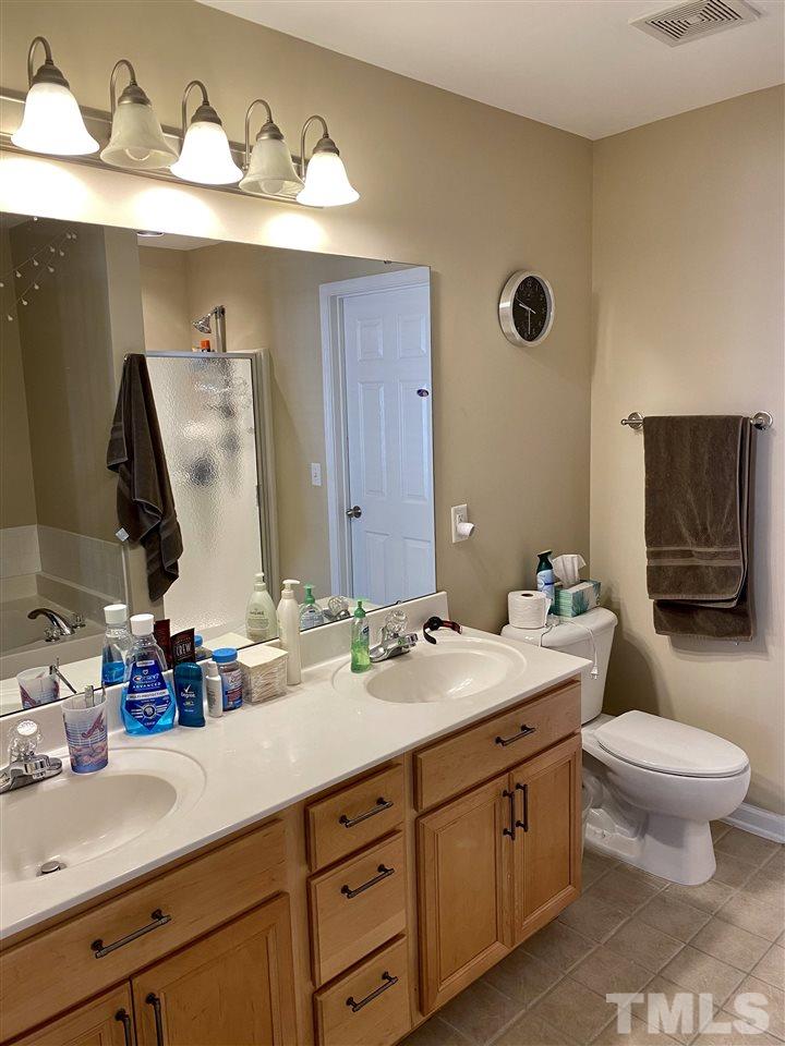 9910 Layla Avenue Raleigh, NC 27617 - Photo 10 of 13 a bathroom with a double vanity sink and a mirror
