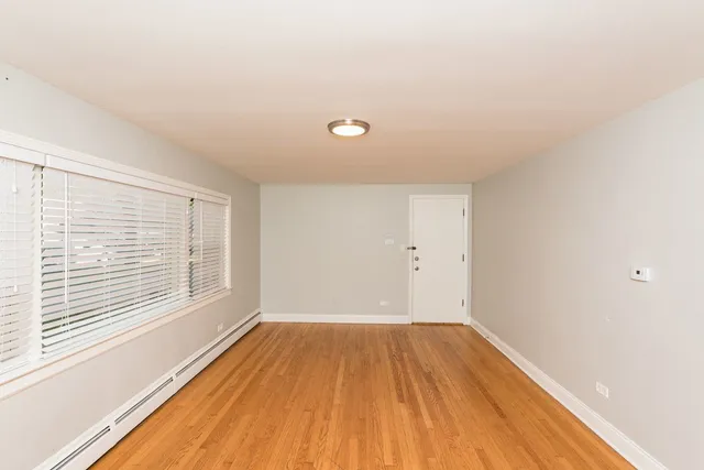 a view of a room with wooden floor and windows