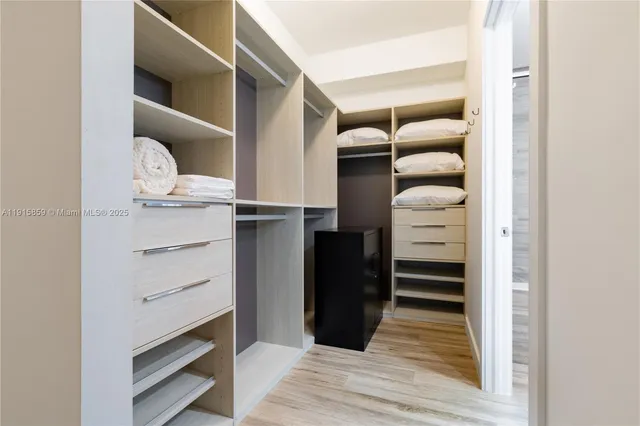 a view of walk in closet with empty racks