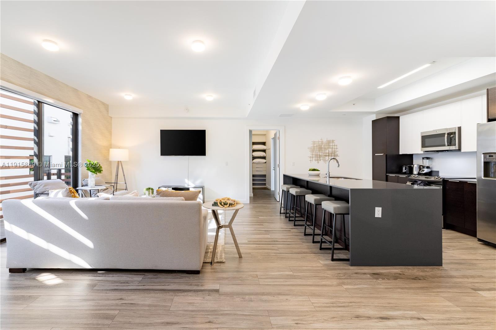 2955 Bird Avenue, Unit PHB Miami, FL 33133 - Photo 3 of 23 a living room with stainless steel appliances kitchen island granite countertop a table chairs and a refrigerator