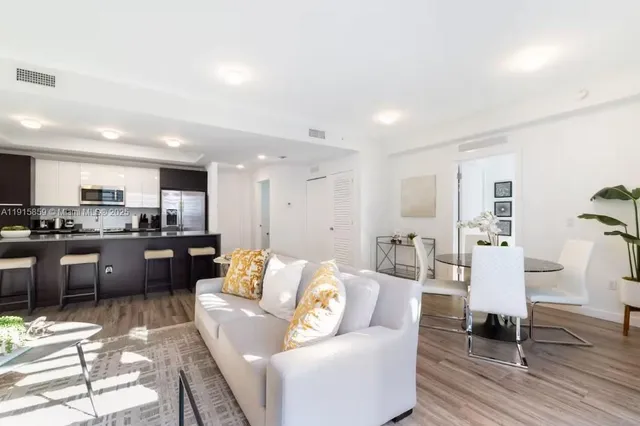 a living room with furniture and kitchen view