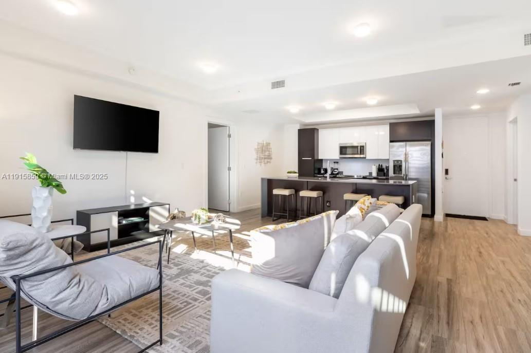 2955 Bird Avenue, Unit PHB Miami, FL 33133 - Photo 5 of 23 a living room with furniture and a flat screen tv