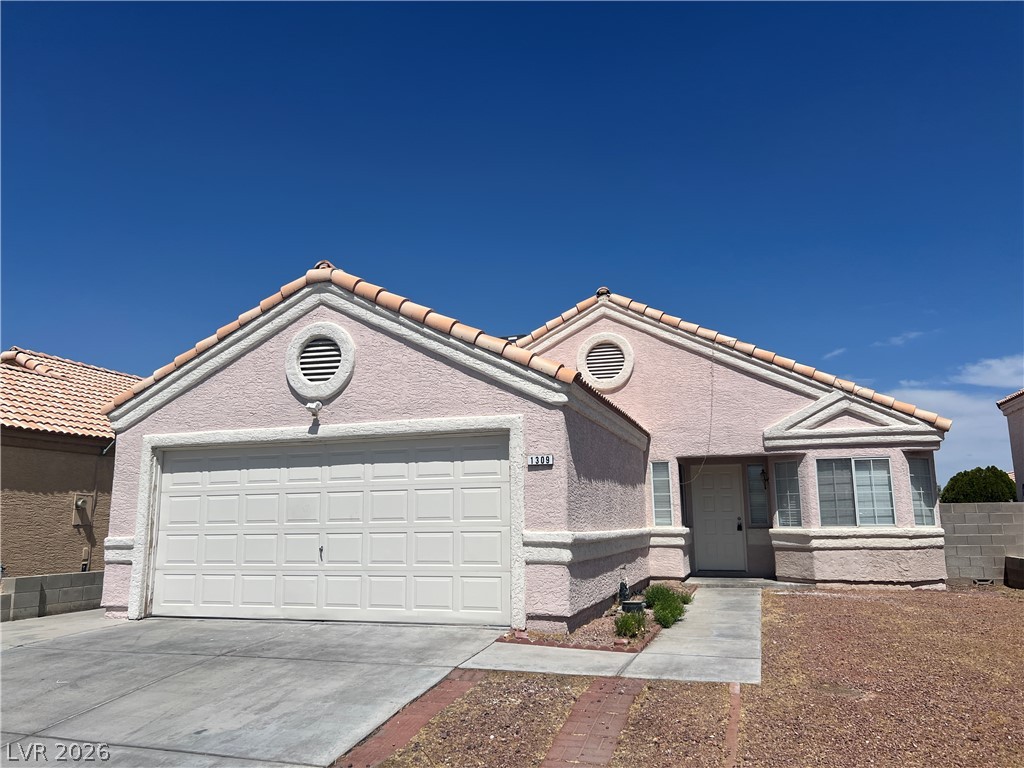 1309 Goldenglow Road Las Vegas, NV 89108 - Photo 1 of 11 A well-maintained facade features a two-car garage and a small front path.