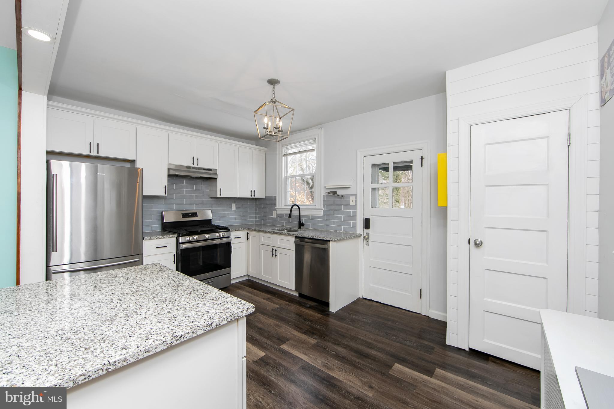 515 Ryers Avenue Cheltenham, PA 19012 - Photo 14 of 33 a kitchen with granite countertop a refrigerator a sink dishwasher and wooden cabinets with wooden floor