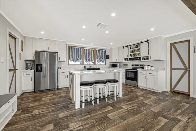 a kitchen with stainless steel appliances granite countertop a stove a sink and a microwave