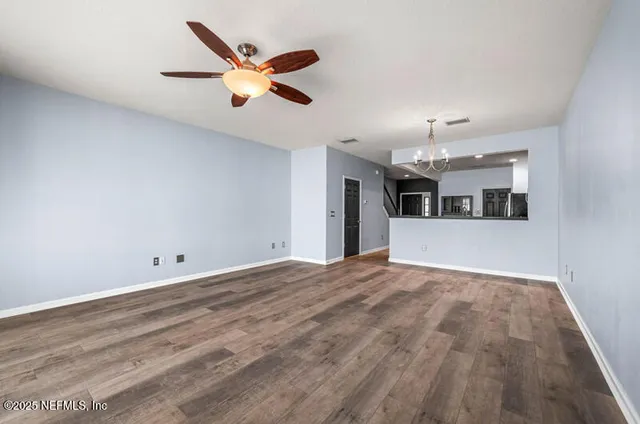 wooden floor in an empty room with a kitchen