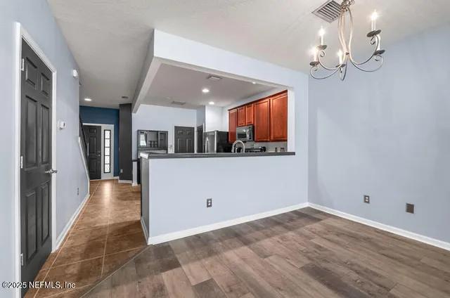 a kitchen with stainless steel appliances kitchen island granite countertop a refrigerator and a stove top oven