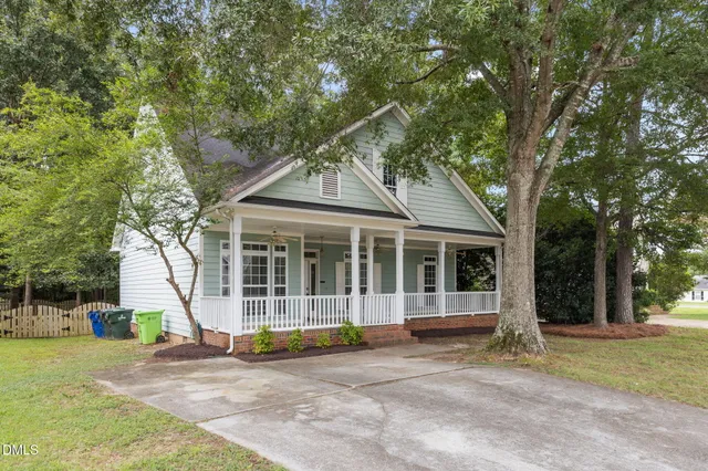 a view of a house with a backyard and tree