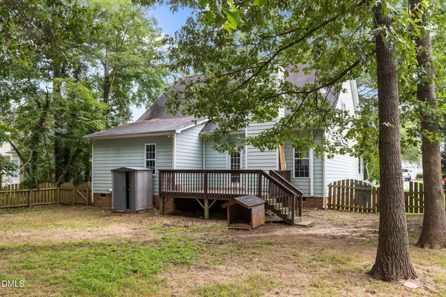 a view of a house with backyard and a tree