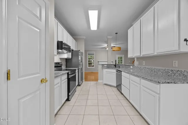 a kitchen with stainless steel appliances granite countertop a refrigerator and a stove top oven
