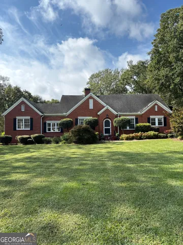 a front view of a house with a yard and balcony