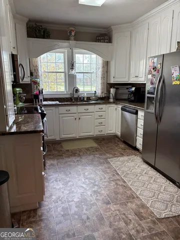 a kitchen with a refrigerator sink and window