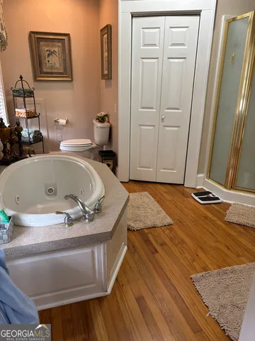 a bath tub sitting in a bathroom next to a wooden cabinet