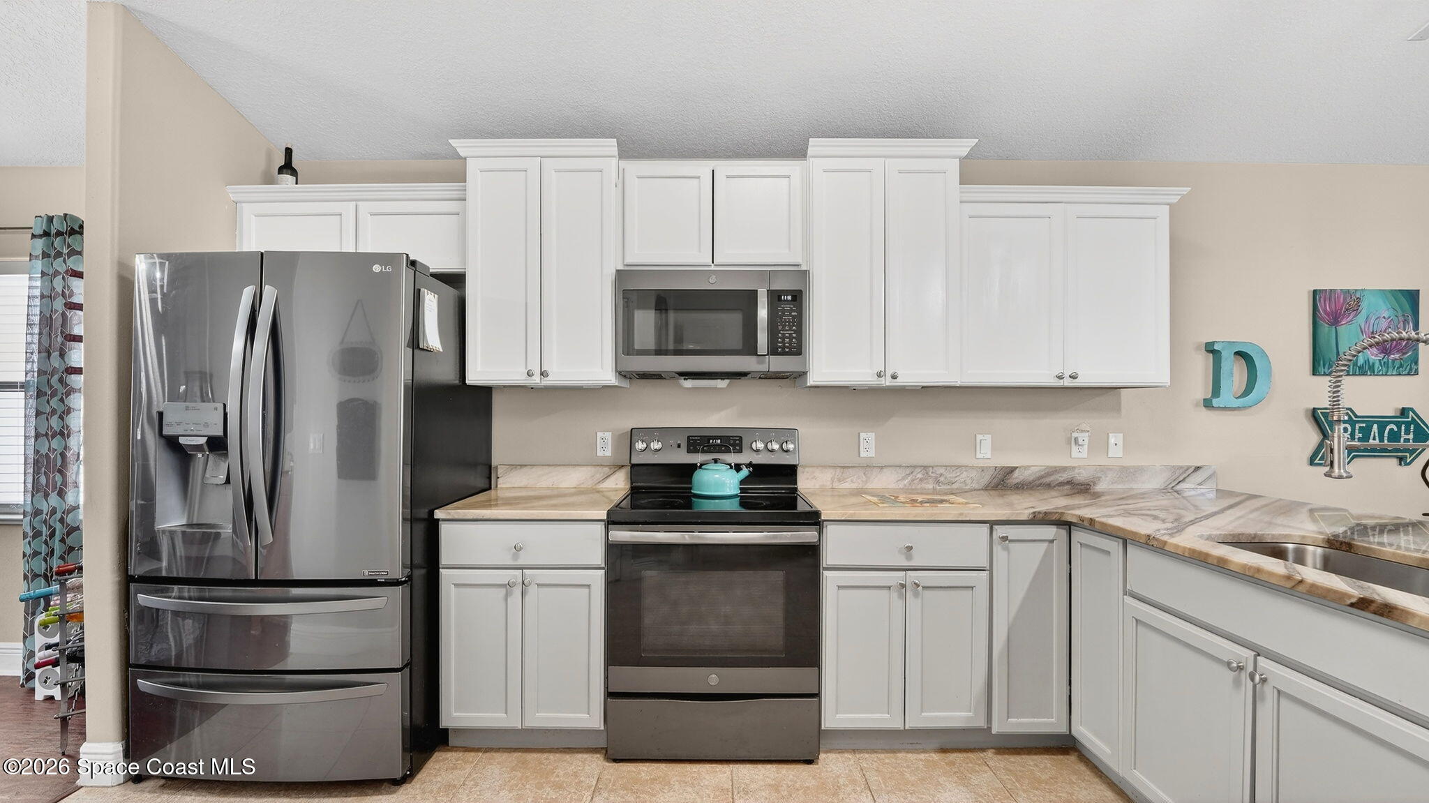 4082 Brantley Circle Rockledge, FL 32955 - Photo 5 of 53 a kitchen with white cabinets and stainless steel appliances