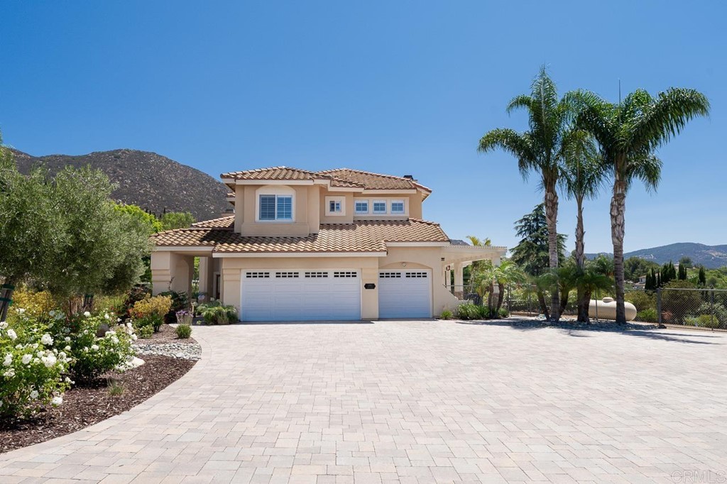 a front view of a house with a yard and palm trees