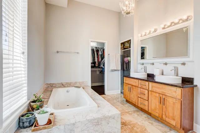 a large bathroom with a tub sink and mirror