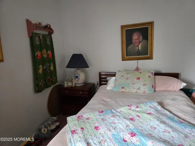 a bedroom with a bed and a lamp on dresser