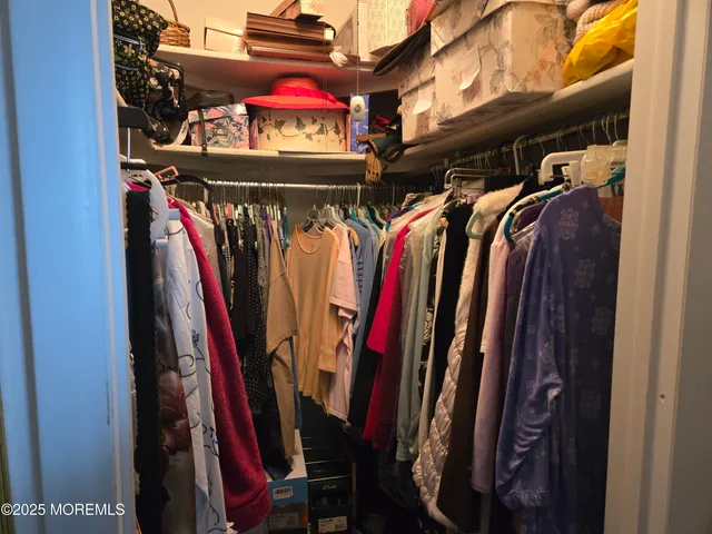 a view of walk in closet with clothes