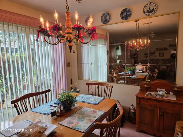 a view of a dining room with furniture and chandelier