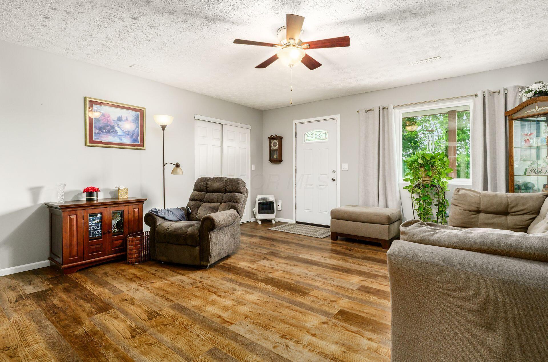 5130 Summit Road Southwest Pataskala, OH 43062 - Photo 3 of 21 Cozy living room with French door, ceiling fan and upgraded vinyl flooring.
