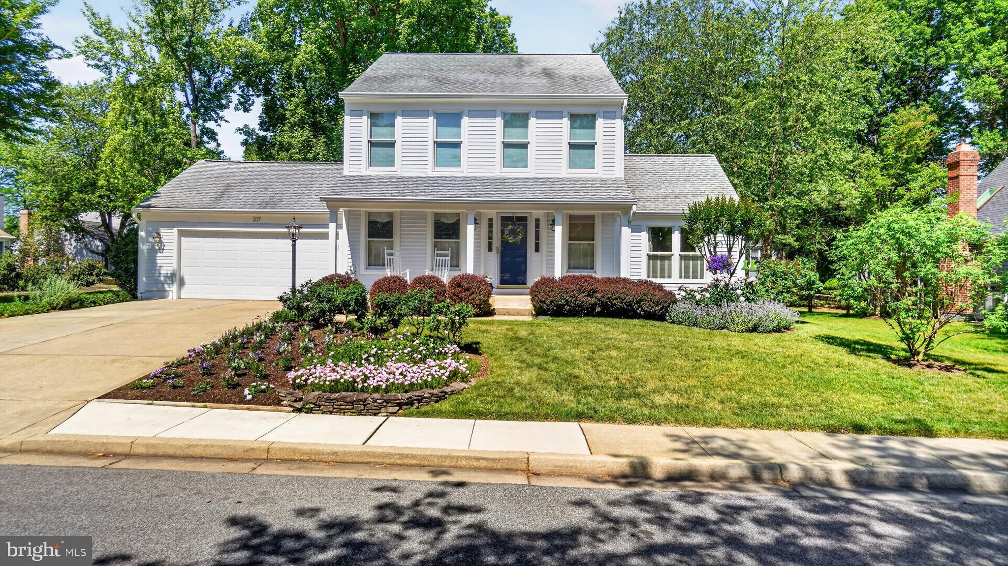 a front view of a house with a yard and potted plants
