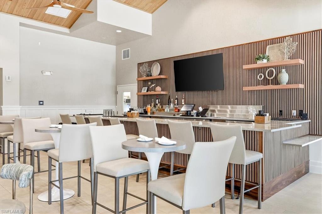 14318 Charthouse Circle Naples, FL 34114 - Photo 35 of 36 a dining room with stainless steel appliances kitchen island granite countertop a dining table chairs and a refrigerator